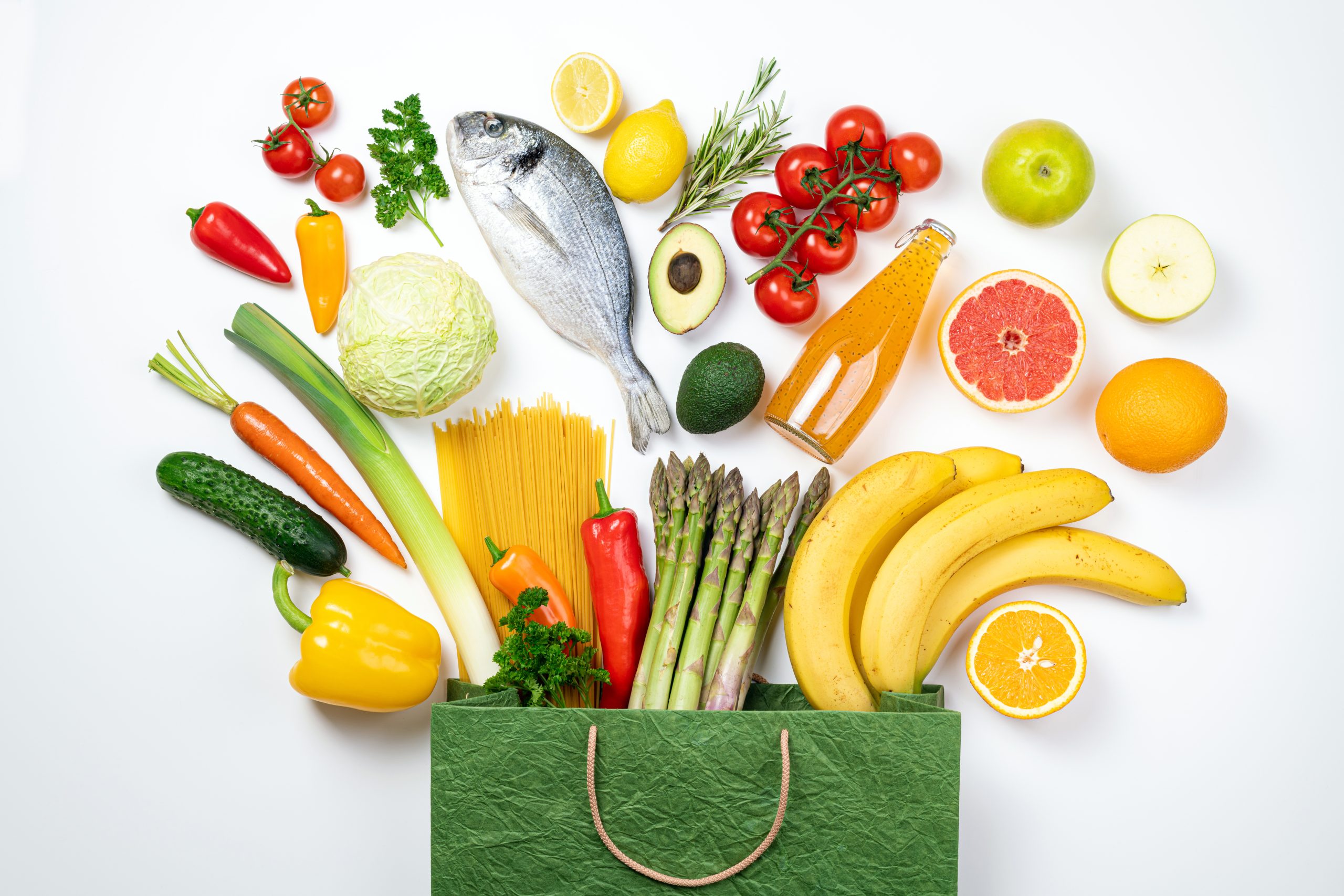 Healthy food background. Healthy food in paper bag fish, vegetables and fruits on white. Shopping food supermarket concept. Healthy eating, food buying